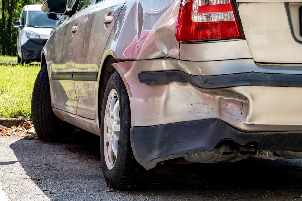 Heavily damaged rear bumper of vehicle in traffic accident