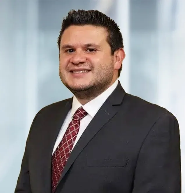 Male attorney in dark suit and burgundy patterned tie, professional headshot