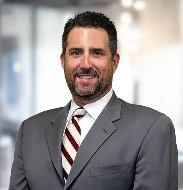 Male attorney in gray suit and burgundy striped tie, professional headshot