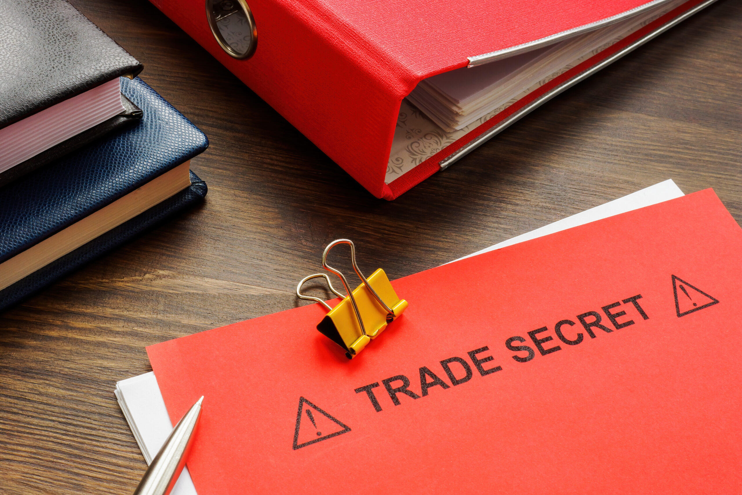 Papers with trade secret and red folder.