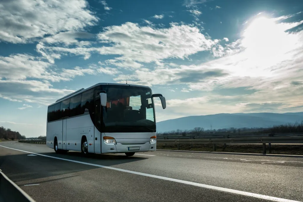 White Modern comfortable tourist bus driving through highway at
