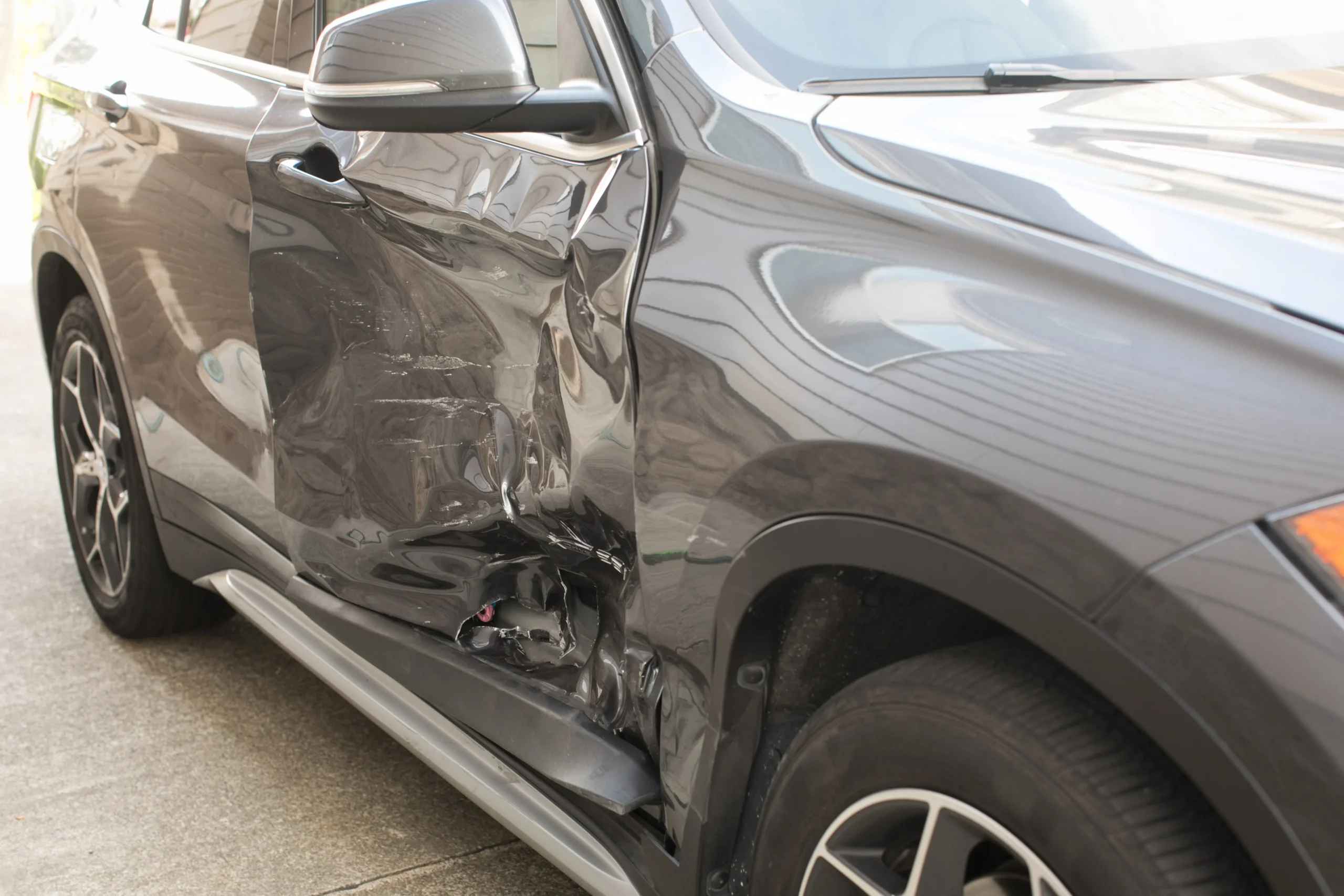 Damaged car with crumpled side panel after a T-bone collision
