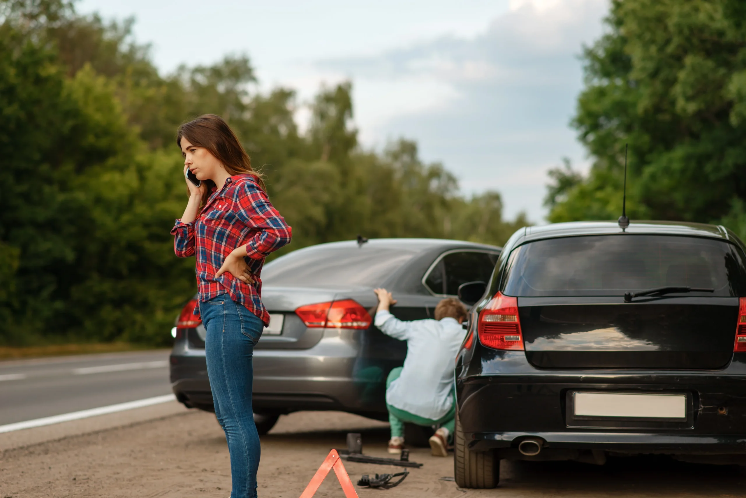 Two drivers standing outside their vehicles after a car accident on a road